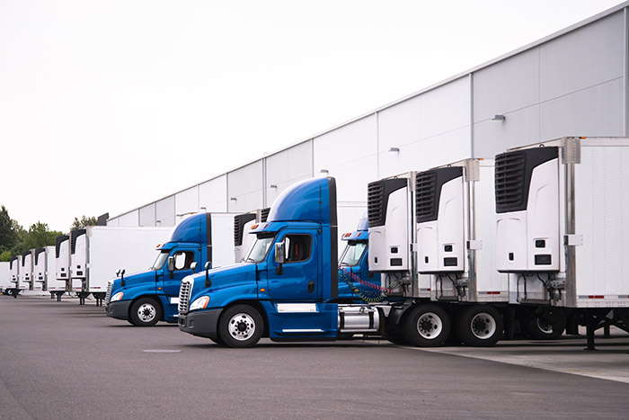 cross dock, reefer trailer, blue semi trucks in a row