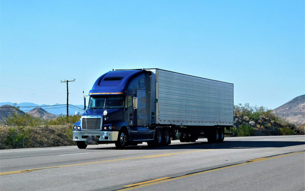 blue dry van on empty road