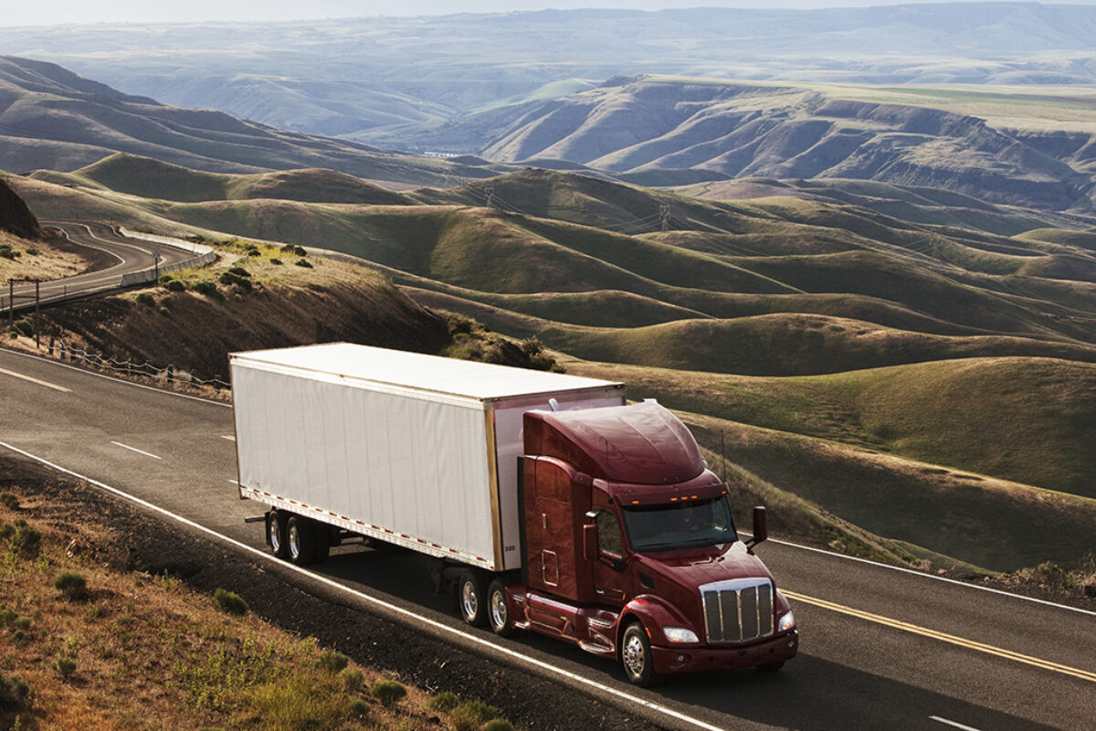 A commercial full truckload semi driving through the high rolling hills of southeastern Washington, USA