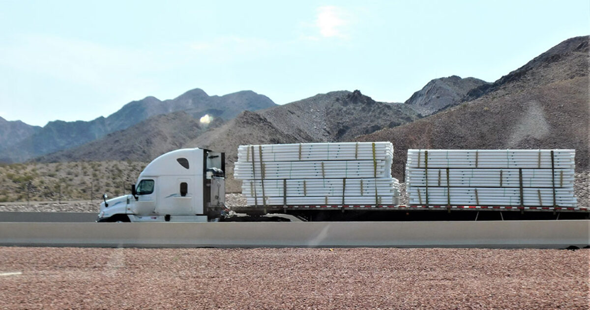 truck driving with flatbed trailer